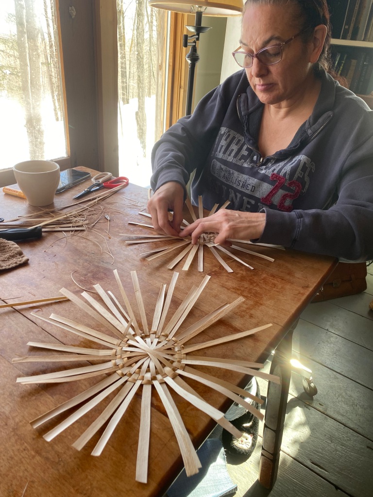 Apprentice Rae Skenandore of Green Bay works on weaving round bottom baskets with Black Ash basketmaker and FY23 Mentor Artist April Stone of Odanah.